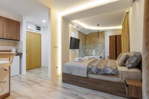 a bedroom with a large bed and a kitchen at Aqua Studios with Spa & Free Parking in Jagodina