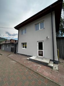 ein weißes Gebäude mit einer Tür an der Seite in der Unterkunft Apart Robert 2 in Bicaz