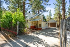 a white house with a gate and trees at Jade Bear Retreat in Big Bear City