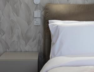 a bedroom with a bed and a switch on the wall at Balzanija Boutique Accommodation in Balzan