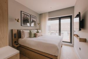 a bedroom with a bed and a large window at Wilde Porto, Clerigos in Porto
