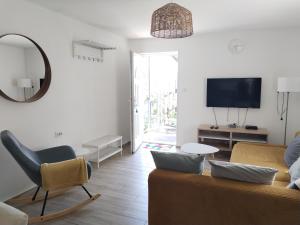 a living room with a couch and a tv at Dömper Döme Apartman 1E in Balatonlelle