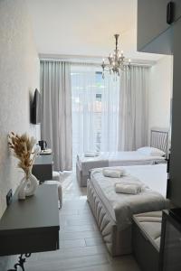 ein Hotelzimmer mit zwei Betten und einem Kronleuchter in der Unterkunft Leader Hotel in Goris