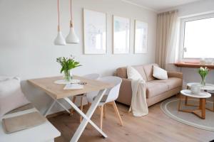 a living room with a table and a couch at Meerblick D9 mit Balkon und Pool in Wangerland