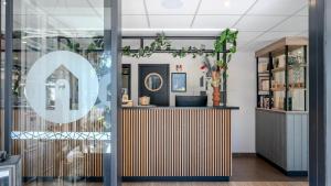 a store front with a glass door with a counter with at Campanile NATURE - Orange in Orange