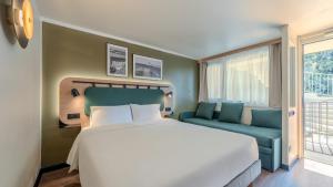 a bedroom with a large bed and a couch at Campanile NATURE - Orange in Orange +43 photos
