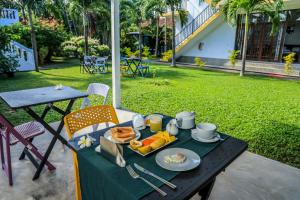 a table with a tray of breakfast food on it at Kyo Garden Villa in Negombo