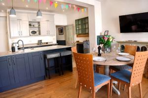 a kitchen with a table and chairs and a kitchen with blue cabinets at Spacious Pretty home in Old Totterdown in Bristol +53 photos