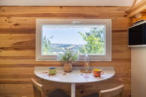 a small table in a kitchen with a window at Tiny House au coeur de la nature in Bessuéjouls
