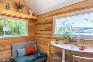 a tiny house with a table and a window at Tiny House au coeur de la nature in Bessuéjouls