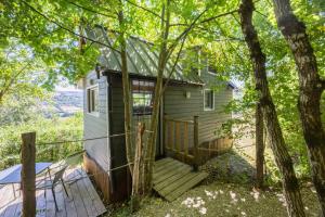 a tiny house in the woods with a porch at Tiny House au coeur de la nature in Bessuéjouls