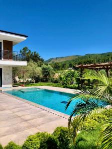 a swimming pool in front of a house at Villa Ada Bohème in Muğla