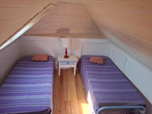 two beds in a attic with a table and a lamp at FONTE NOVA Setubal in Setúbal