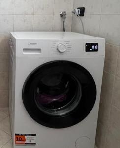a dryer with a washing machine in a room at Lilac Cozy Retreat in Angera