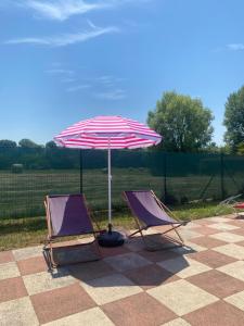 two chairs and an umbrella on a patio at Lilac Cozy Retreat in Angera