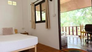 a bedroom with a bed and a balcony at Zen Trinity House in Ko Phangan
