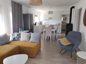 a living room with a couch and a kitchen at Dömper Döme Apartman 1E in Balatonlelle