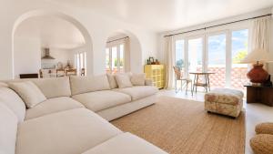 a living room with a white couch and a table at Casa Branca - Caparica in Charneca