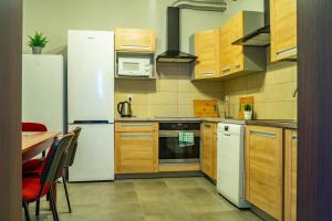 eine Küche mit Holzschränken und einem weißen Kühlschrank in der Unterkunft Hotel Wołów in Wołów