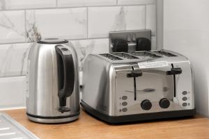 a toaster and toaster sitting on a kitchen counter at Chic & Modern Beckenham Retreat in Beckenham