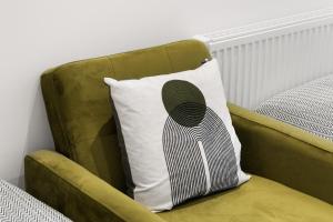 a green chair with a pillow on it at Chic & Modern Beckenham Retreat in Beckenham