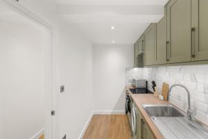 a kitchen with a sink and a counter top at Chic & Modern Beckenham Retreat in Beckenham