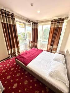 a bedroom with a large bed with a window at Harmony Inn in Almaty