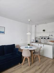a living room with a table and a blue couch at Latarnik in Karwia