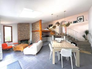 a kitchen and living room with a table and chairs at Gîte cottage & spa in Joze