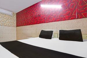 a room with a bed with a red wall at Hotel O Shivam In in New Delhi