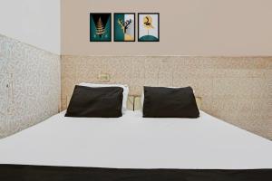 a bedroom with a white bed with two pillows at Hotel O Shivam In in New Delhi