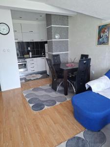a living room with a dining room table and a kitchen at Stan na dan -Bratunac- in Bratunac +14 photos