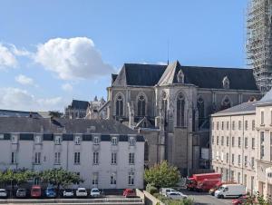 a church and a white building with cars parked in front at Chambre chez l'habitant - Arty & Élégante - SDB privée in Nantes