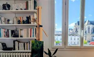 a room with two windows and a book shelf with books at Chambre chez l'habitant - Arty & Élégante - SDB privée in Nantes