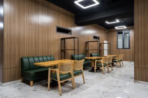 a conference room with wooden walls and tables and green chairs at Carlton Hotel Tashkent in Tashkent