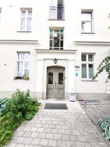 a white house with a gray door at Loft Hause Sopot in Sopot