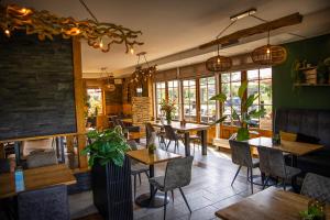 a restaurant with tables and chairs and windows at Hotel Inn Salland in Raalte