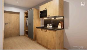 a kitchen with wooden cabinets and a black counter top at Gästehaus Attenhauser in Unterammergau