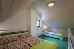 a attic bedroom with a bed and a window at Agroturystyka Wesoła Chmura - dom w Masywie Śnieżnika in Kletno