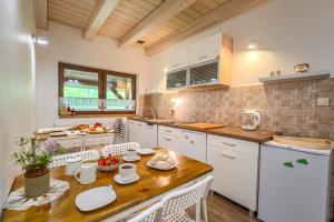 a kitchen with a wooden table and white cabinets at Agroturystyka Wesoła Chmura - dom w Masywie Śnieżnika in Kletno