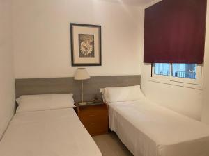 a room with two beds and a window at Mandala apARTments, confort y encanto a pie playa in Calafell