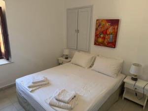 a bedroom with a white bed with towels on it at Villa Marco Polo in Agia Marina