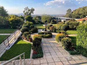 a garden with a fountain and bushes at Cradle Mount Hotel Suites in Muldersdrift