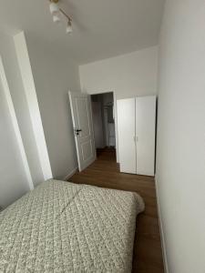 an empty bedroom with a bed and a hallway at JD Apartment Sobieskiego in Gniezno