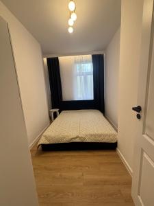a small bedroom with a bed and a window at JD Apartment Sobieskiego in Gniezno