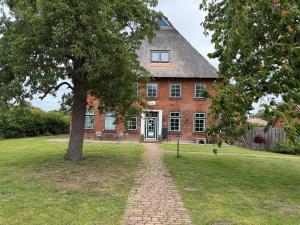 a brick house with a tree in front of it at Hof Wiesentau in Bösdorf