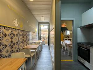 a restaurant with tables and chairs and a kitchen at A Beira Hostel in Aveiro