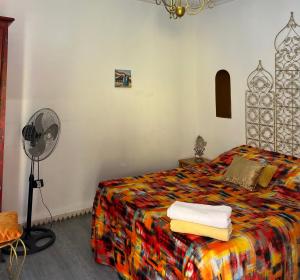 a bedroom with a bed and a fan at Riad Le Lieu in Tiznit