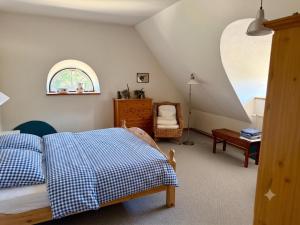 a bedroom with a bed with a blue and white blanket at Hof Wiesentau in Bösdorf