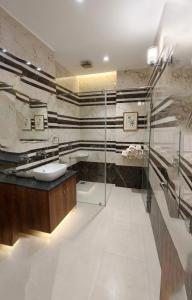 a bathroom with a glass shower and a sink at Hotel Kanak in Gangānagar +23 photos